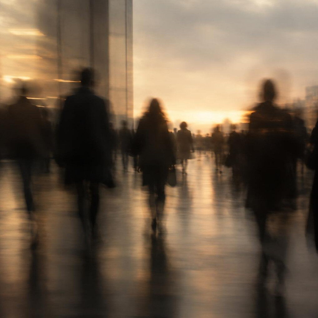Blurred silhouettes of a crowd in warm ambient light